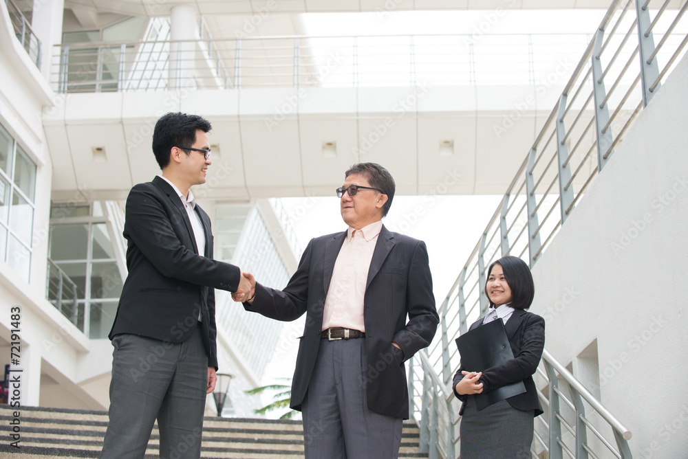 business people shaking hands with a team of colleagues around t business people shaking hands with a team of colleagues around t