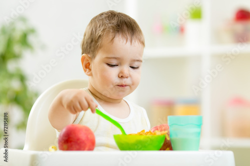 kid eating healthy food on kitchen