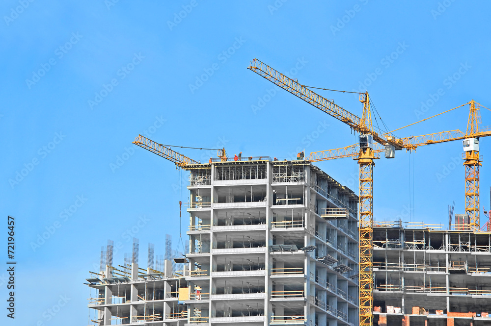 Crane and building construction site against blue sky Crane and building construction site against blue sky