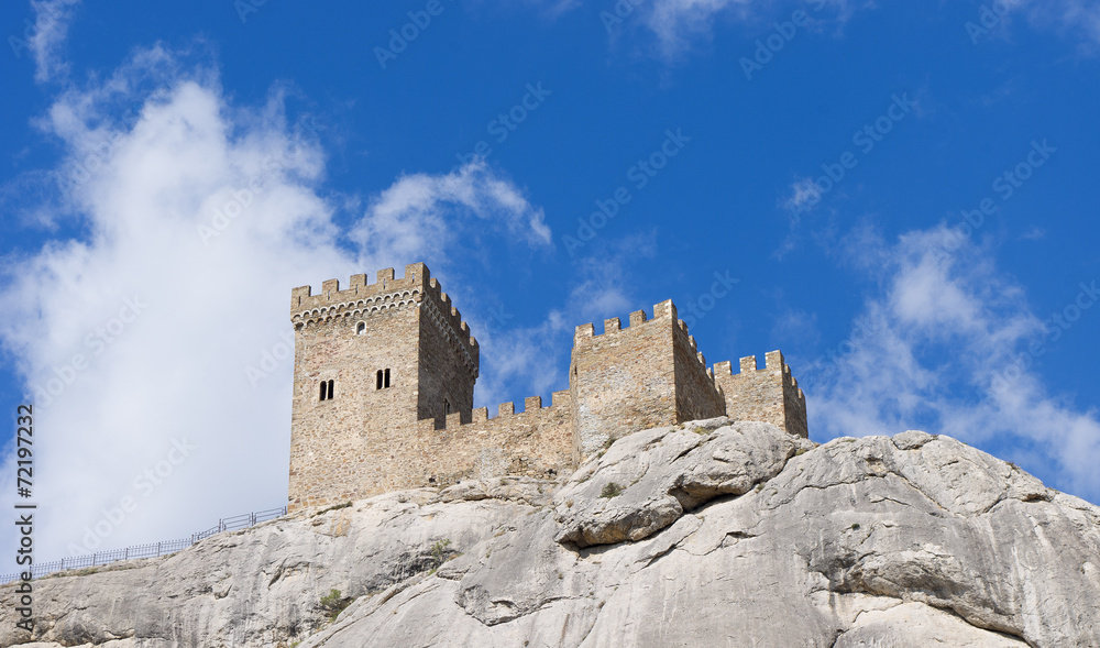 The tower of the ancient castle on a blue sky background