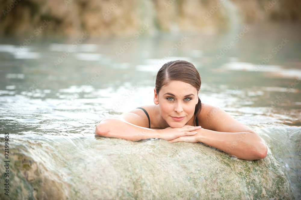 Obraz premium Pretty young woman takes a bath in the natural thermal waters of