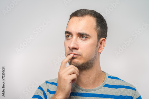 Portrait of the young thinking man looks up