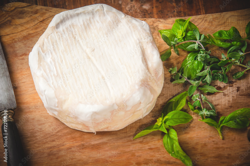 Smelly blue cheese on a wooden rustic table with knife and basil Smelly blue cheese on a wooden rustic table with knife and basil