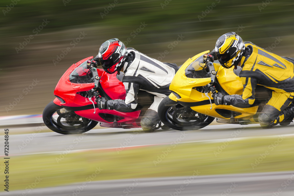 Two motorcycle leaning into a fast corner on track