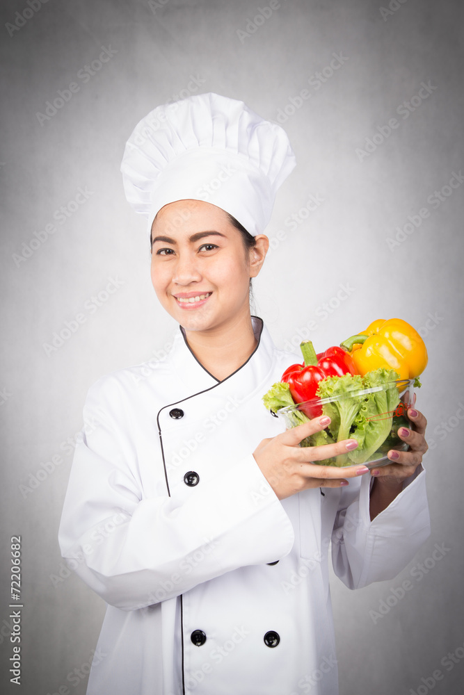 Woman chef holding bowl of fresh vegetables Woman chef holding bowl of fresh vegetables
