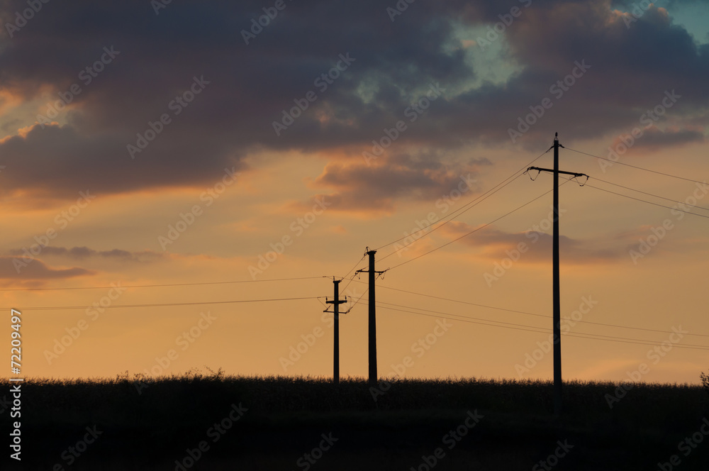 sunset and three electric pylons