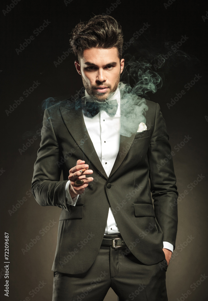 Elegant business man holding a cigarette in his right hand. Elegant business man holding a cigarette in his right hand.
