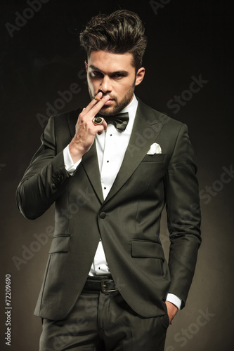 business man holding one hand in pocket while smoking