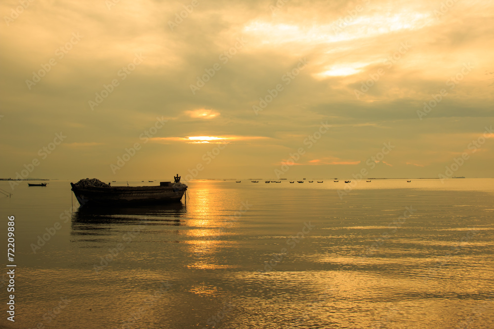 old boat in front of sunset background in golden color tone