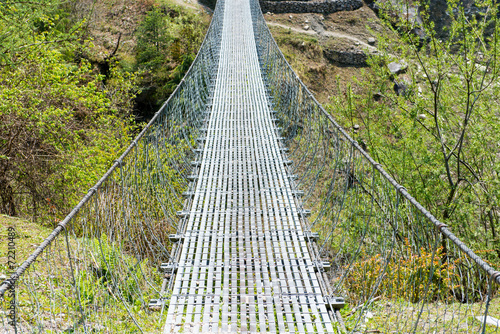 Fototapeta Naklejka Na Ścianę i Meble -  Suspension bridge. Annapurna Circuit - turists trek in Himalayas