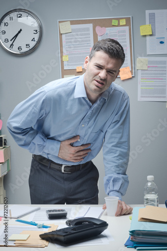Stressed businessman with stomachache photo
