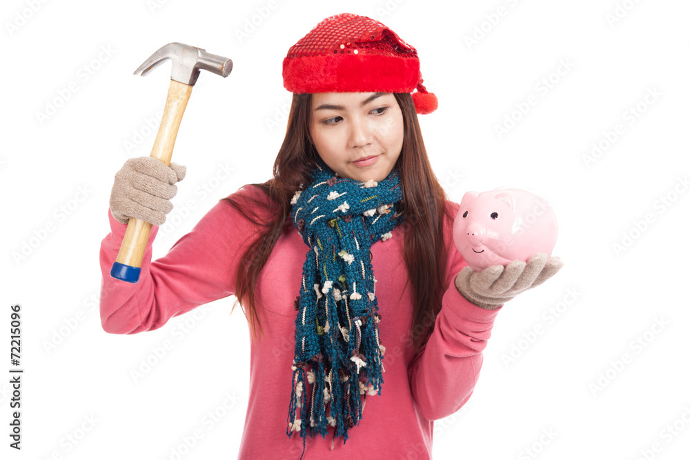 Asian girl with red christmas hat ,hammer and piggy bank Asian girl with red christmas hat ,hammer and piggy bank