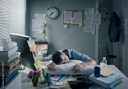 Businessman sleeping in the office overnight photo