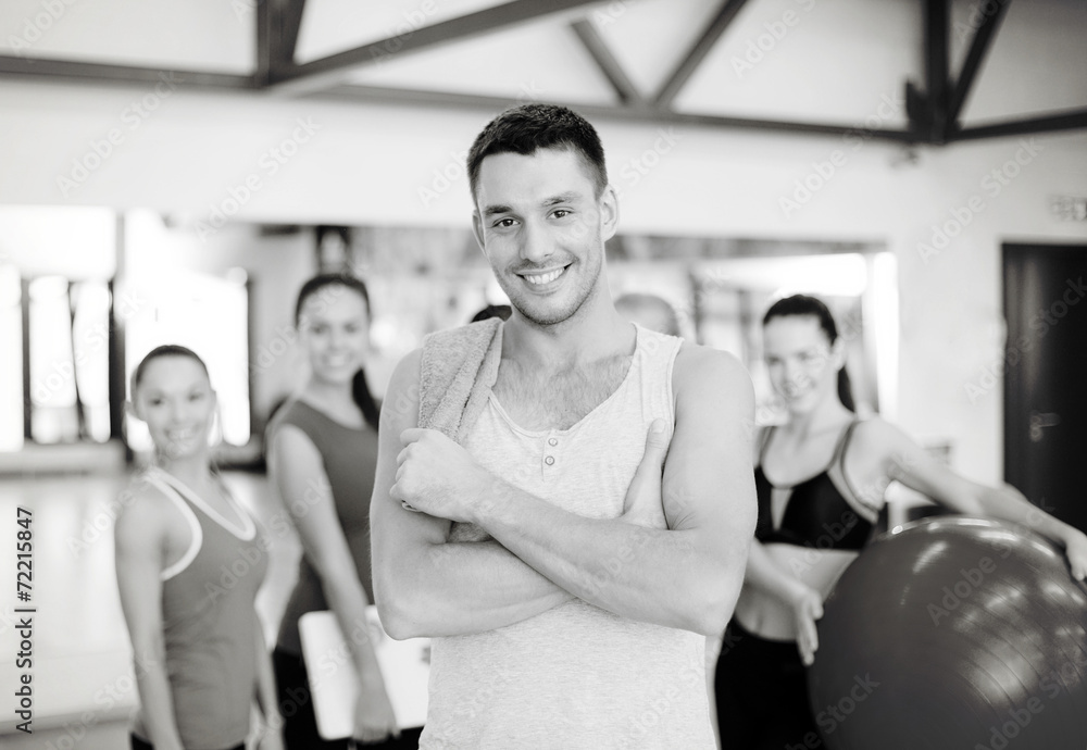 smiling man standing in front of the group in gym smiling man standing in front of the group in gym