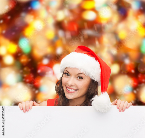 woman in santa helper hat with blank white board © Syda Productions