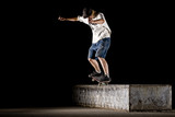 boy doing skateboard trick in skate park on night