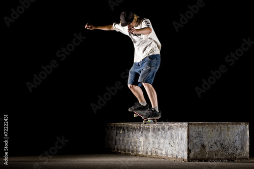 boy doing skateboard trick in skate park on night