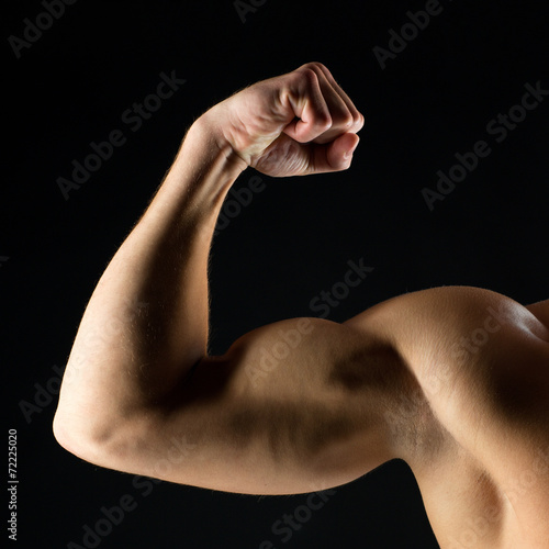 close up of young man showing biceps