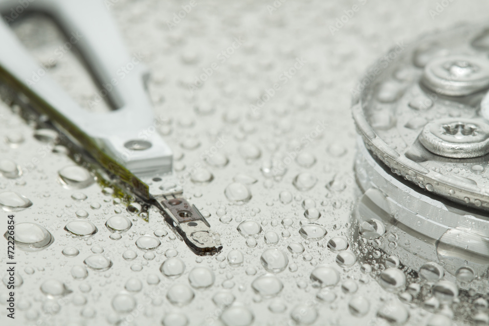 Inside of open and broken HDD with water drops, narrow focus