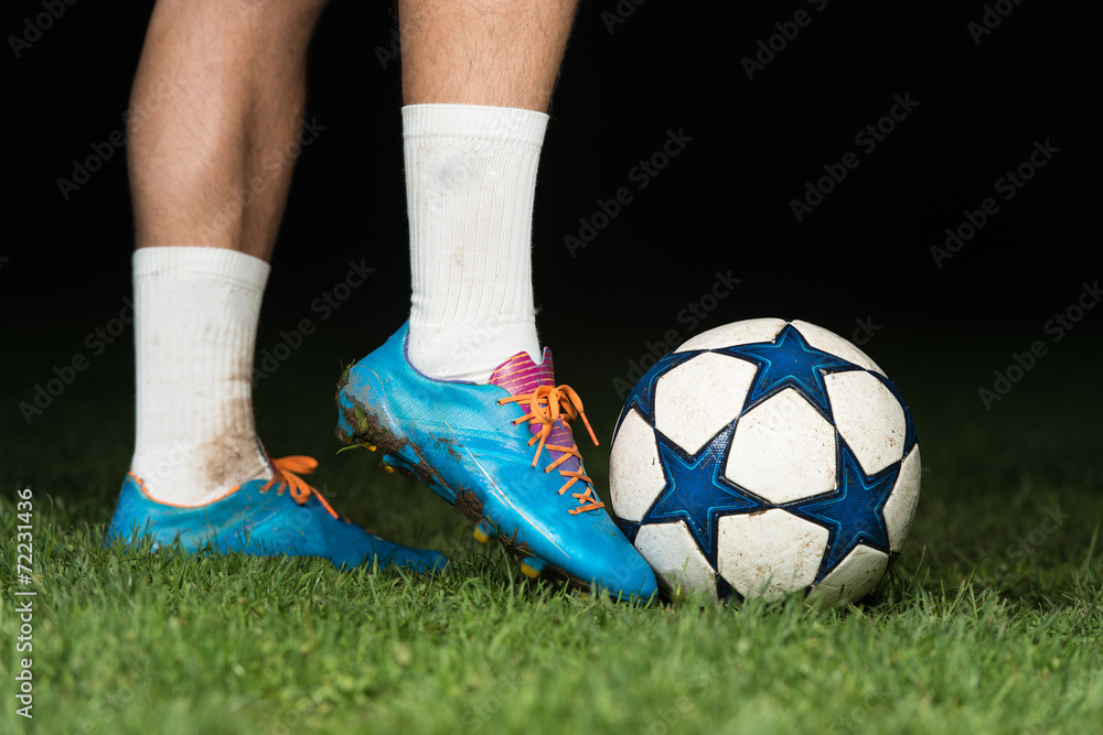Legs Of Player With Ball On Dark Background