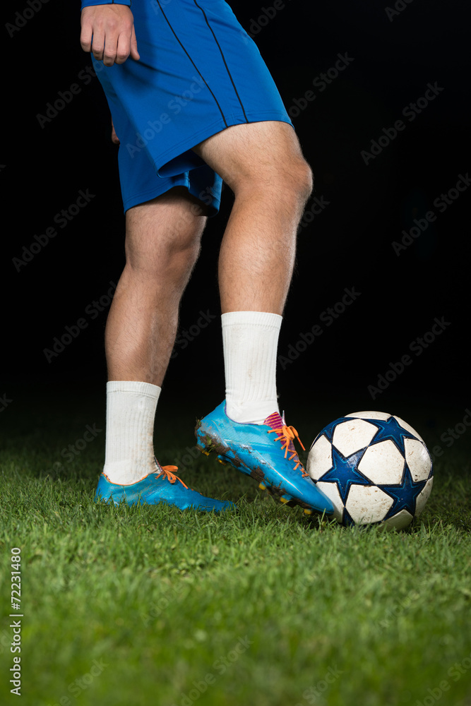 Legs Of Player With Ball On Dark Background Legs Of Player With Ball On Dark Background