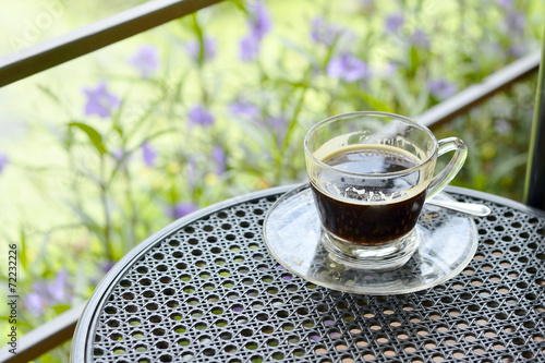 black coffee on terrace with Ruellia tuberosa garden