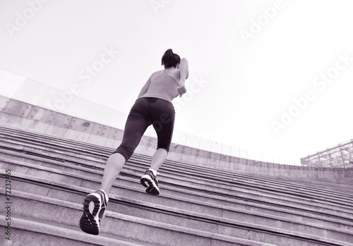 young fitness woman running up on stairs 