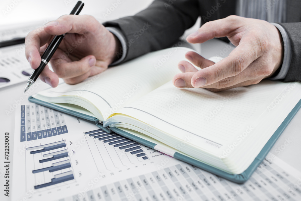 Businessman analyzing investment charts. Accounting Businessman analyzing investment charts. Accounting