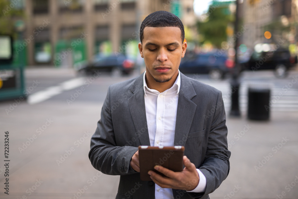 Young African American black Latino man using tablet pc Young African American black Latino man using tablet pc