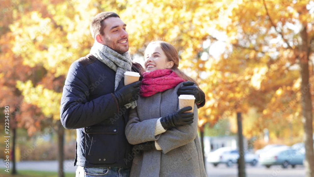 smiling couple with coffee cups in autumn park smiling couple with coffee cups in autumn park