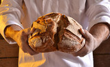Panadero. dividiendo un pan grande.Probando pan.