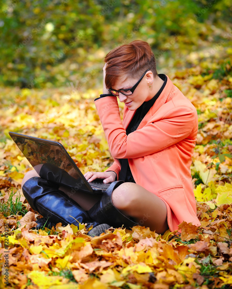 Cute woman with laptop in the autumn park Cute woman with laptop in the autumn park