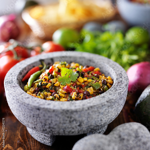 fire roasted corn and black bean salsa in stone molcajete