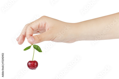 female teen hand holds cherry