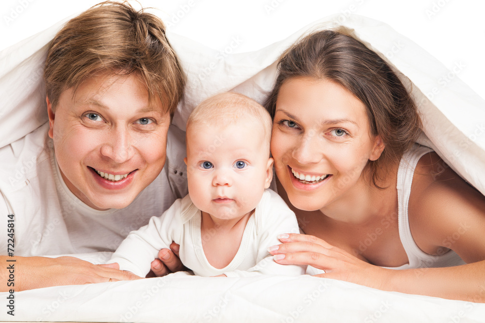 happy family under blanket on the bed at home happy family under blanket on the bed at home
