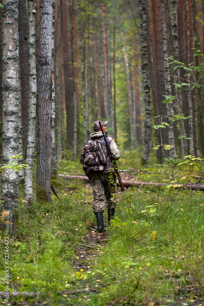 hunter with gun in the forest