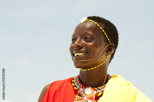 Young massai warrior man posing on bright sunny beach in Kenya photo