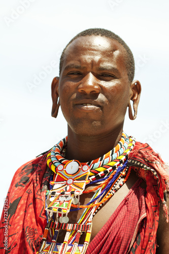 Young massai warrior man posing on bright sunny beach in Kenya