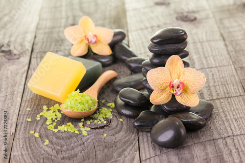 Yellow Moth orchids and black stones on weathered deck