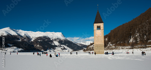 Steeple in the frozen lake Resia, Curon Venosta, Dolomites