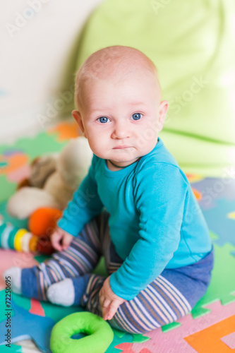 Cute little baby playing with colorful toys indoors