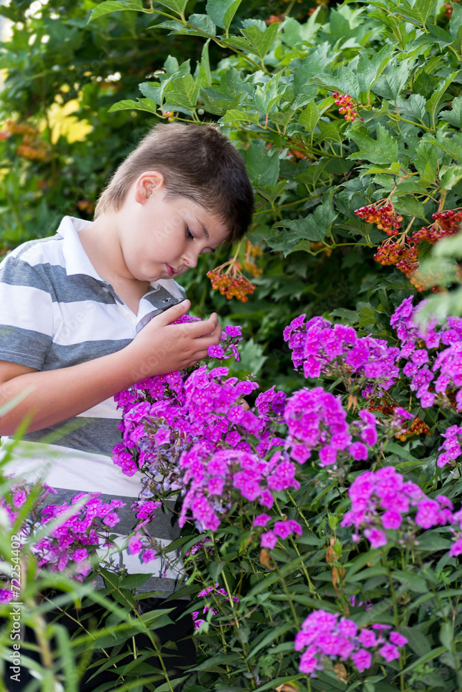 Teen boy about flowers in garden Teen boy about flowers in garden