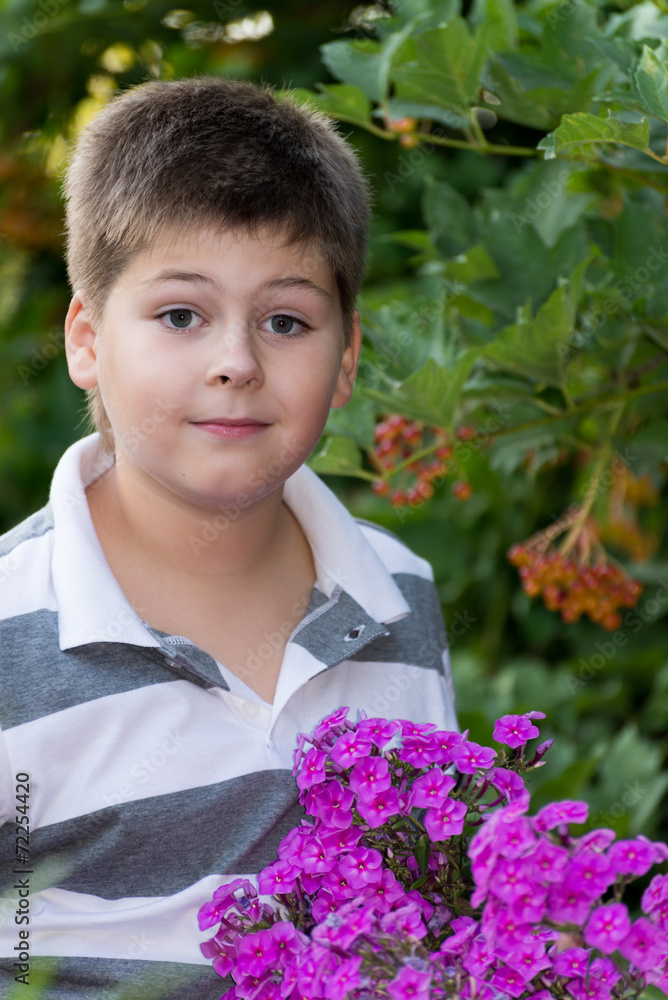 Teen boy about flowers in garden Teen boy about flowers in garden