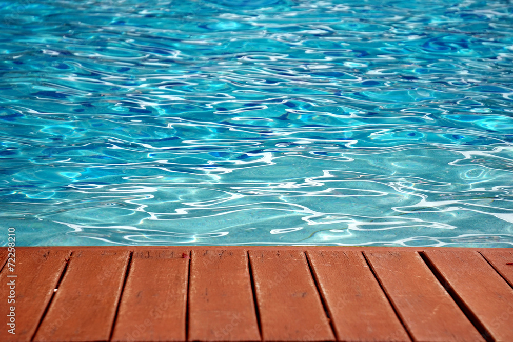 blue swimming pool with wood flooring stripes summer vacation