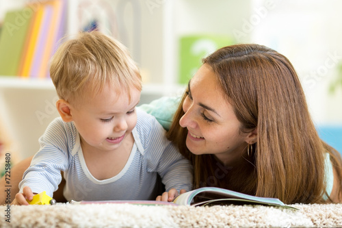 mother reading a book to kid at home