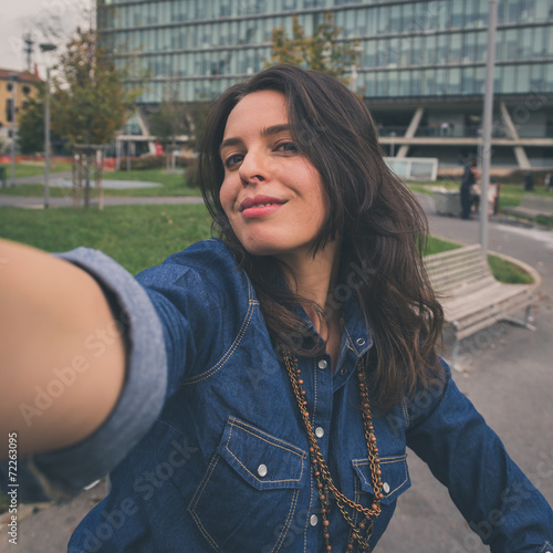 Pretty girl taking a selfie in the city streets