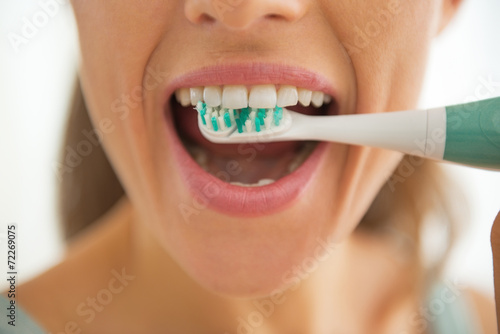 Closeup on woman brushing teeth