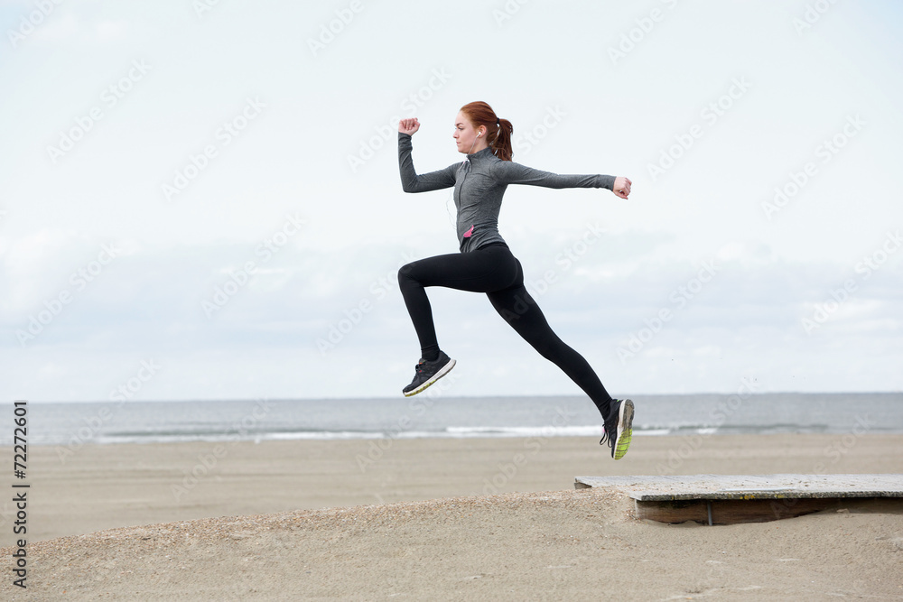 Young female runner jumping outdoors