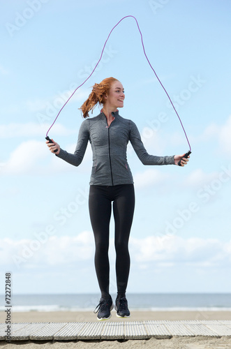 Young woman skipping with jump rope outdoors