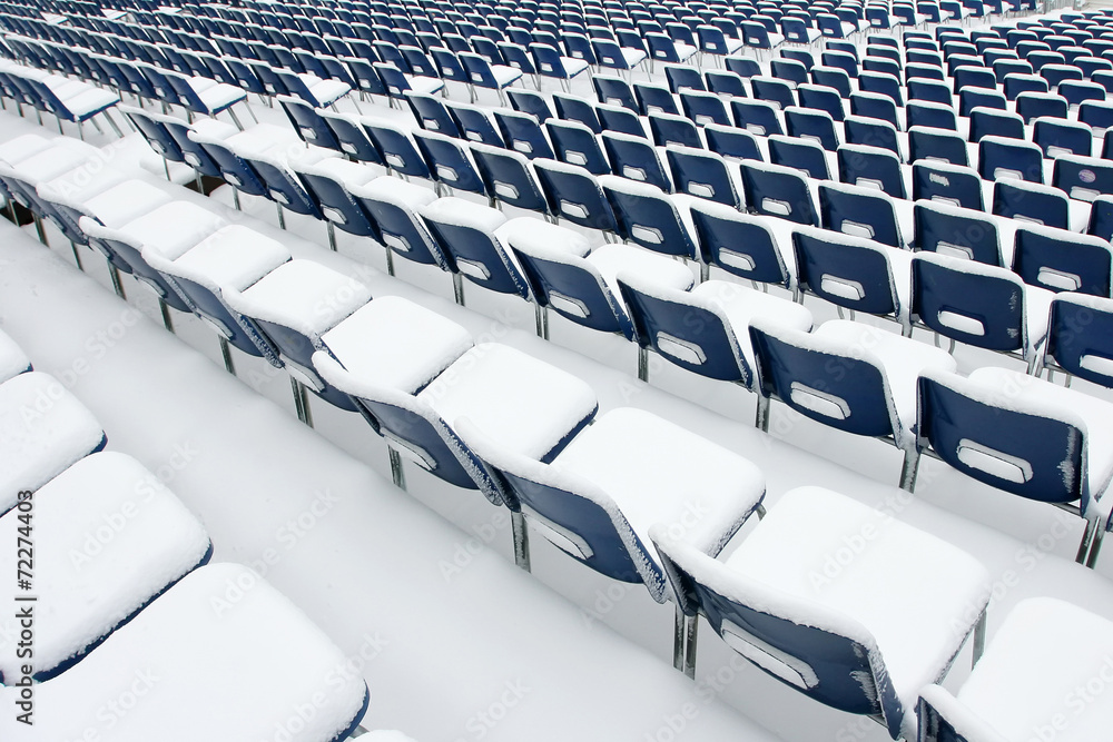 Fototapeta premium Empty plastic chairs covered in snow